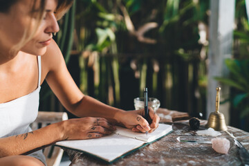 Woman write in notebook on terrace of resort hotel