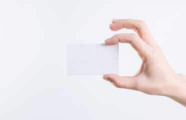 A hand holding a blank business card