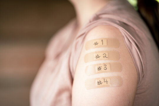 female with rolled up shirt sleeve to show the bandaid after the1, 2, 3 and 4 coronavirus vaccines shot in the shoulder. To simulate covid 19 vaccine doses.