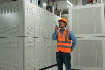 Service engineer using radio communication in electrical  high voltage room.engineer in helmet...