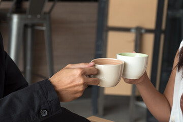 Two cups of coffee cups in man and woman hands.