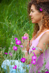 woman with  hands in namaste gesture outdor in summer field with flowers