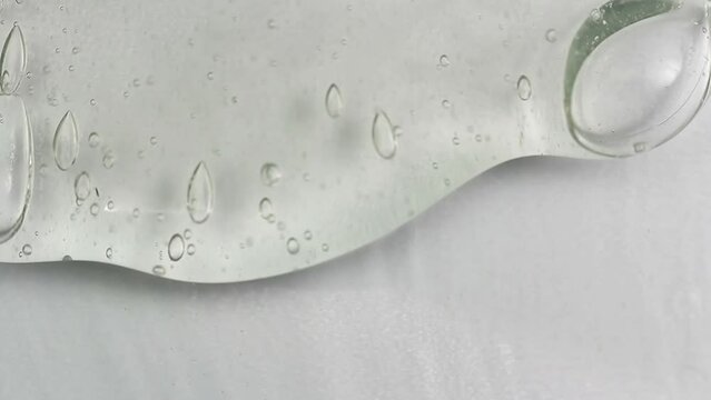 Clean transparent shampoo with bubble flowing from bottom. Macro cosmetic, cleaner texture background, isolated on white