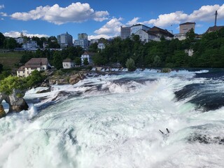 Refreshing view of Rhine falls, a powerful waterfall in Schaffhausen, Switzerland, view during bright summer evening.