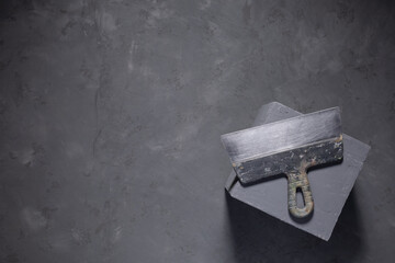 Concrete cube and construction work tools on floor background texture. Cement block and putty knife