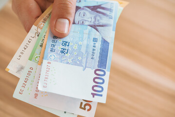 Hand holding Korean money.