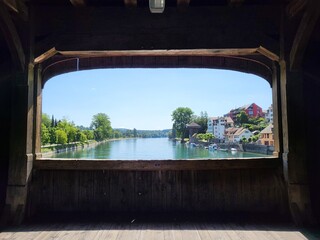 View towards river, Diessenhofen Switzerland town and Gailingen am Hochrhein Germany village, from the window of Rheinbrucke, an old wooden bridge connecting both place.