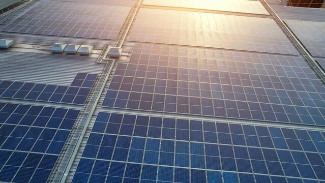 Drone flying over photovoltaic solar panels mounted on building roof. Production of renewable energy concept. Clean energy industry in Nonthaburi, Thailand. drone footage. 4k
