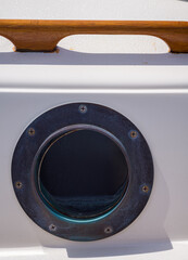 Nautical Background  Closeup Photograph of a Bronze Porthole and Teak Handrail on a Vintage Boat