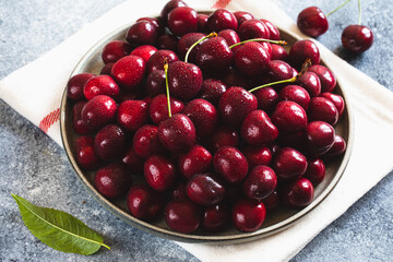 Composition of sweet cherries on a plate with water drops. Summer and harvest concept. Cherry macro. Vegan, vegetarian, raw food