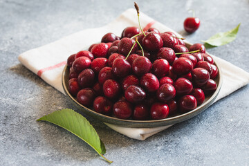 Composition of sweet cherries on a plate with water drops. Summer and harvest concept. Cherry macro. Vegan, vegetarian, raw food