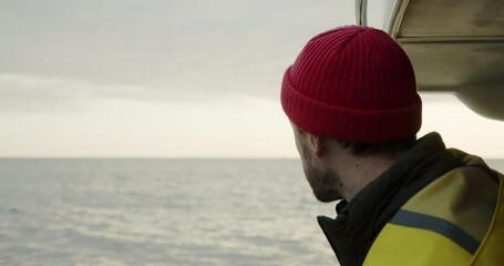 Portrait of a smiling sailor sailing on a boat at sunset