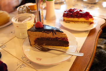 Chocolate cake with a raspberry on top in a cafe