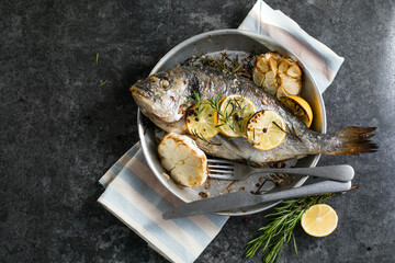 Delicious Grilled dorado fish with lemon and parsley. Whole Bbq sea bream baked. Dorado grill. Ketogenic, keto or paleo diet lunch, Healthy food trend. Top view,