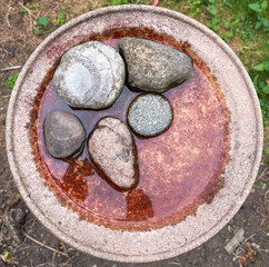 Smooth round stones in a bowl of water