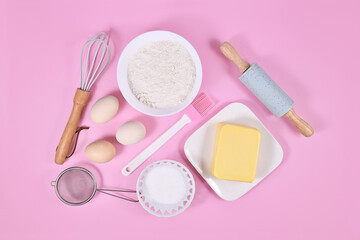 Obraz na płótnie Canvas Cake dough ingredients and baking tools on pink background