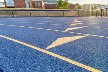 Inspiring close up of the start of an exchange zone on a new blue running track with yellow lane...