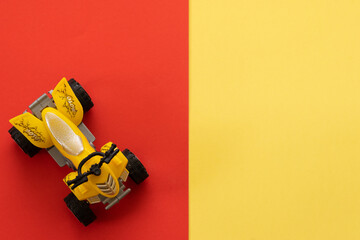 ATV-shaped toy on a yellow and red background
