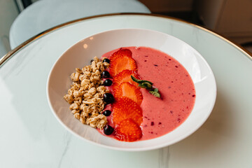 Strawberry porridge with granola and berries