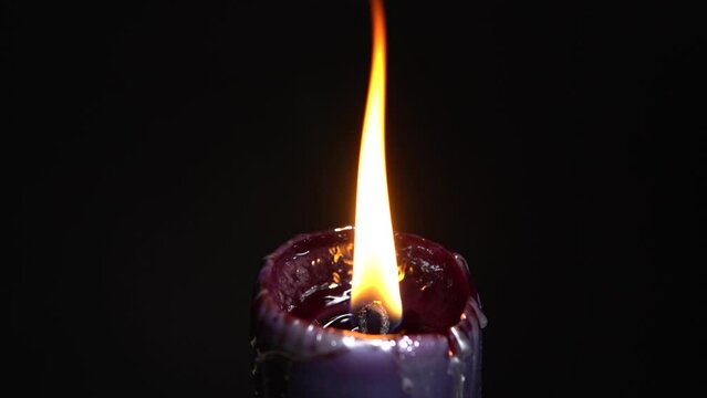 Black candle selective focus. Witchcraft altar for satanic rituals. Dark background for performing mystical esoteric ritual. Macabre and witch spells darkness for Halloween concept.