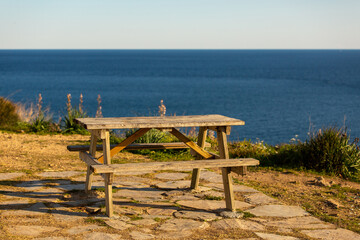 Naklejka na ściany i meble An empty picnic table by the sea