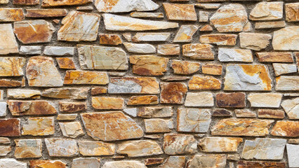 Nice colorful stone wall in beige, orange tones, close up, background