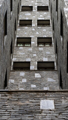 Tall gray stone brick building, set of geometric shapes
