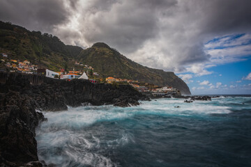 Beautiful nature landscape with Atlantic Ocean and lava rock natural swimming pools in Porto Moniz, Madeira, Portugal. Long exposure picture, october 2021