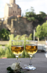 Two glasses of white wine and flowers outside on a sunny day