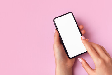 Woman using smart phone on pink background. Closeup of female hands with natural manicure with a mobile phone. Online shopping, business, education, communication concept. Isolated white screen mockup