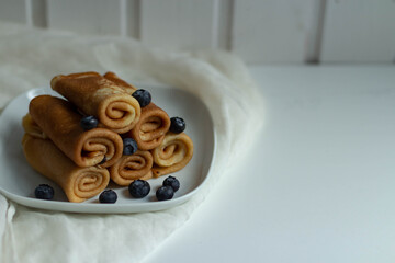 Fototapeta na wymiar Pancakes on a white plate with blueberries.