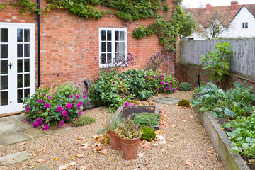 UK garden in autumn with gravel, patio and French doors