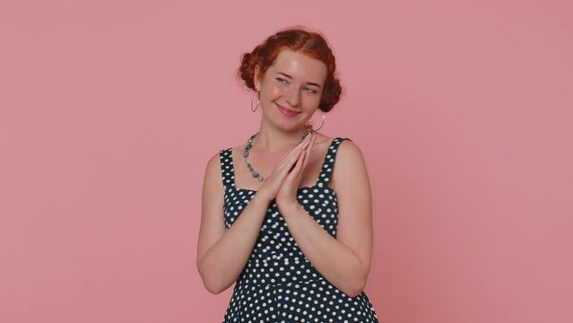 Sneaky cunning woman with tricky face gesticulating and scheming evil plan, thinking over devious villain idea, cunning cheats, jokes and pranks. Redhead girl on pink studio background alone indoors