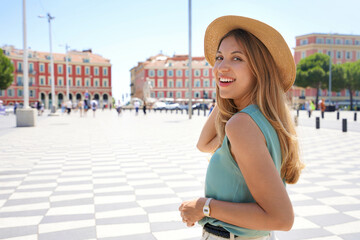 Portrait of attractive fashion woman turns around and smiling at camera in Nice City, France
