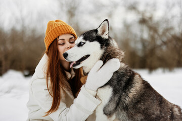 cheerful woman winter clothes walking the dog in the snow fresh air