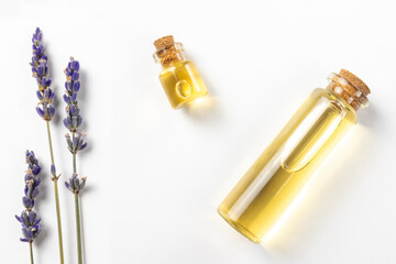 Lavender oil essence yellow colour in glass bottles. Top view flat lay with lavender flowers