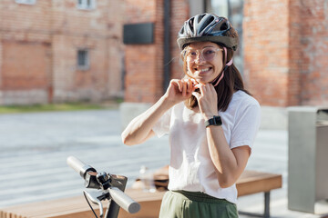 Woman is wearing protection helmet for riding electric scooter