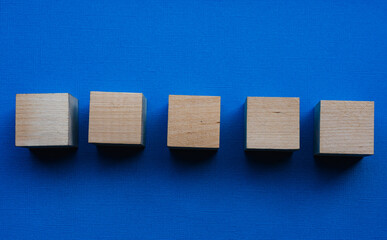 Five wooden cubes on a blue background, mocap