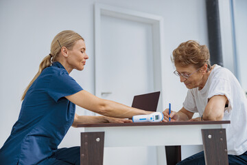 Fototapeta premium Female patient signing treatment agreement in doctor's office in clinic. High quality photo