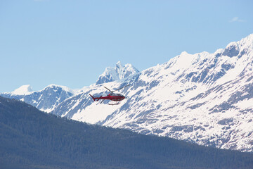 Helicopter mid-flight in front of an Alaskan mountain