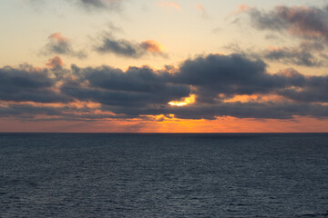 Naklejka na ściany i meble Partially clouded sunset in the ocean