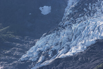 Tidewater glacier impacting the side of a mountain at the coastline