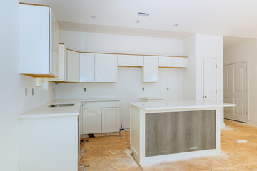 In a set of furniture under construction, white kitchen wooden cabinets were installed with a home improvement view