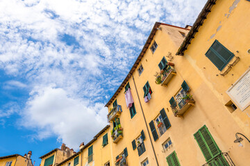 Inside the yellow walls of the Piazza del Anfiteatro, the ancient amphitheater inside the walled Tuscan city of Lucca, Italy.