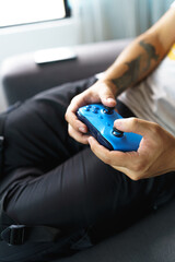 Remote blue video game control details, relaxed lifestyle with modern hobbies, holding with their hands, technology and leisure © Alejandro