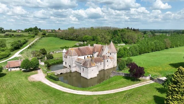 Aerial view of Buranlure water castle in the middle of a lush green meadow in the Loire valley