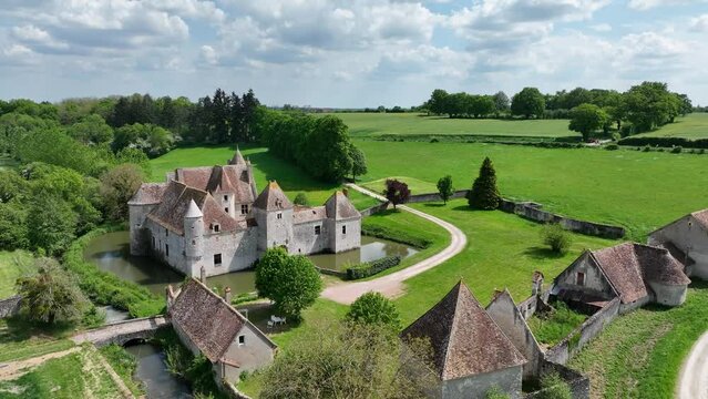 Aerial view of Buranlure water castle in the middle of a lush green meadow in the Loire valley