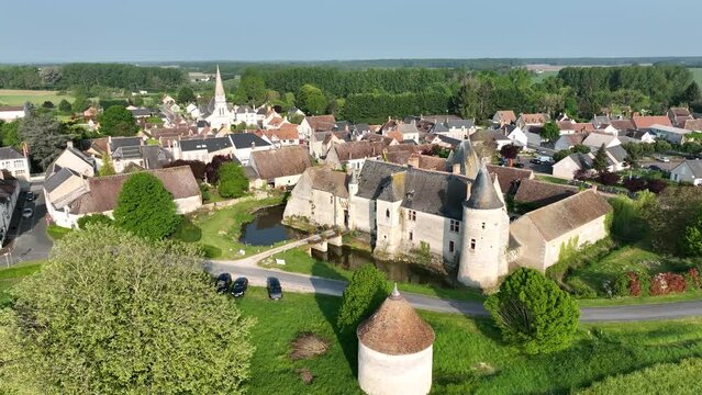 Circling around Ch&eacute;mery water castle in the Loire valley, surrounded by water filled moat, accessible through a drawbridge, with Gothic palace, great hall, outer circular tower