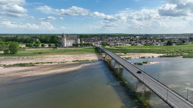 Approaching Sully sur Loire fairytale French water castle with circular towers, gate house from across the Loire river 