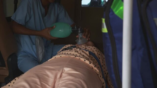 Professional nurse or doctor helping a patient about respiratory with oxygen mask on ambulance before to hospital, first aid and resuscitation, emergency and assistant, medical and insurance concept.